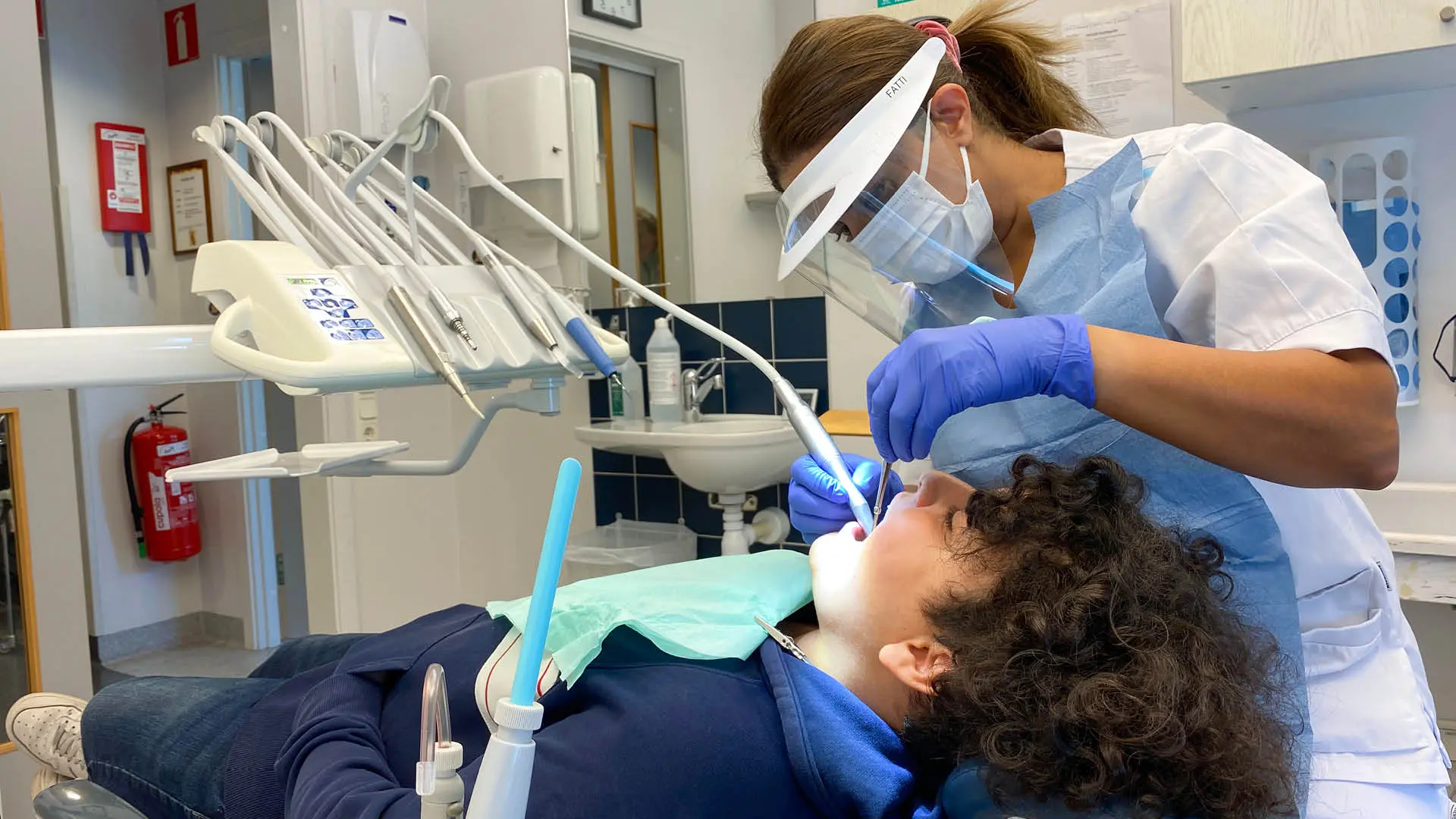 Tandhygienist undersöker en ung patient